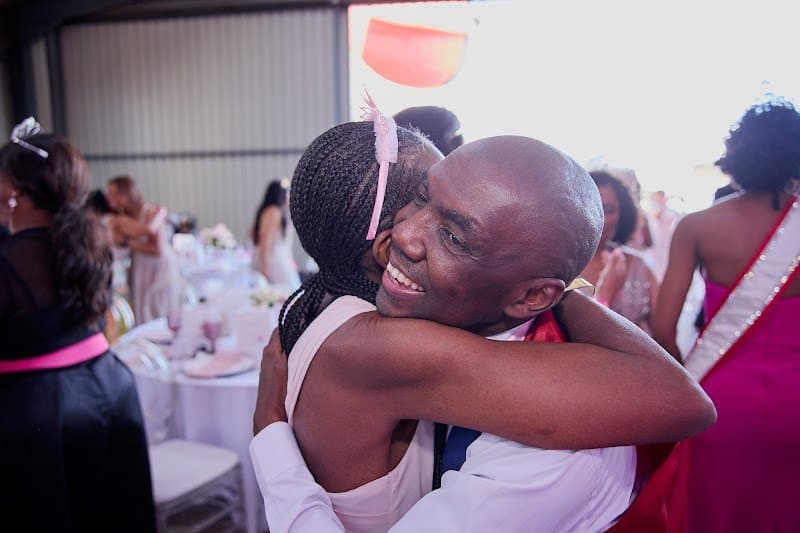 Two guests share an embrace at a foundation community event
