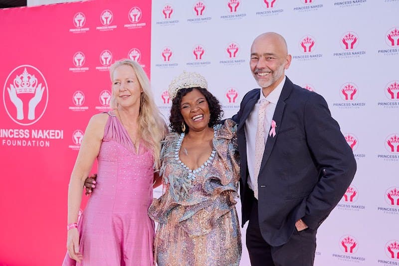 Foundation guests pose together at a photo wall.