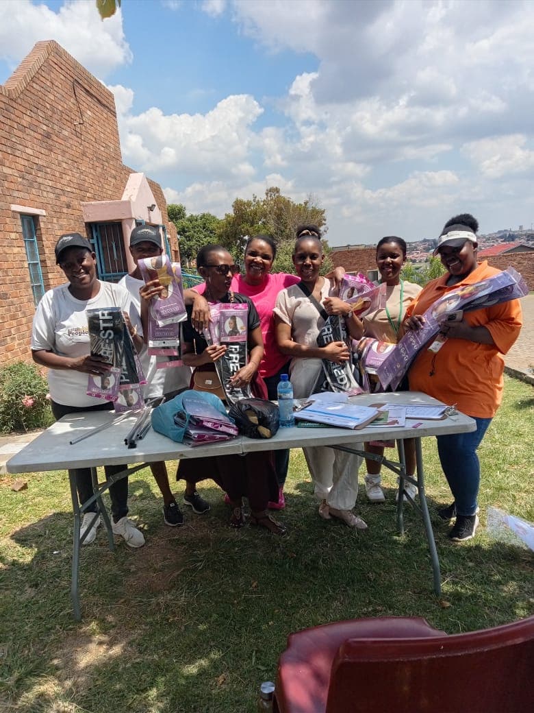 Community members beside an outdoor table with packaged donations